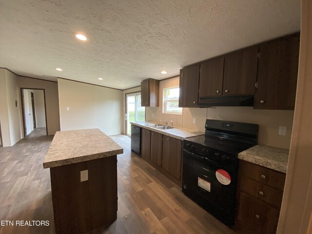 kitchen with black stove, dishwasher, hardwood / wood-style floors, a center island, and sink