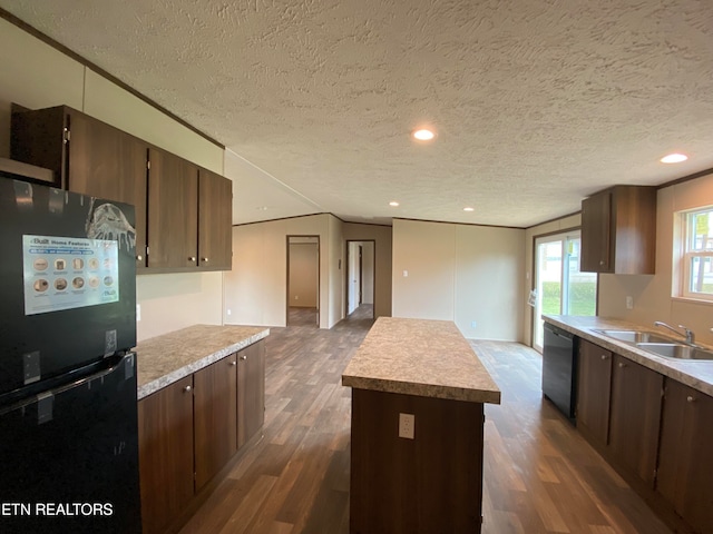 kitchen featuring sink, stainless steel dishwasher, a textured ceiling, dark hardwood / wood-style floors, and black refrigerator