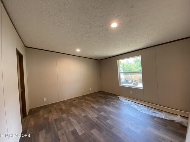 unfurnished room featuring a textured ceiling and dark hardwood / wood-style flooring