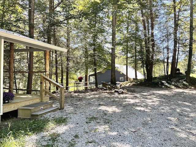 view of yard featuring gravel driveway and a wooden deck