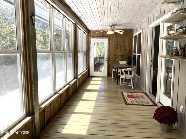 unfurnished sunroom featuring wooden ceiling and a ceiling fan