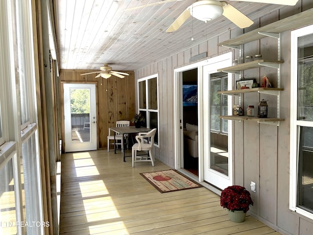 sunroom featuring wood ceiling and a ceiling fan