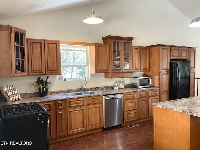 kitchen featuring hanging light fixtures, black appliances, glass insert cabinets, and a sink