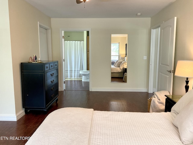 bedroom with dark wood-type flooring, baseboards, and ensuite bathroom