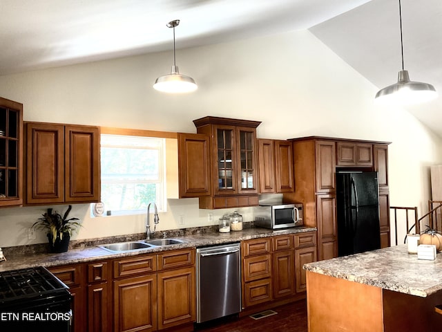 kitchen featuring glass insert cabinets, a sink, hanging light fixtures, and black appliances