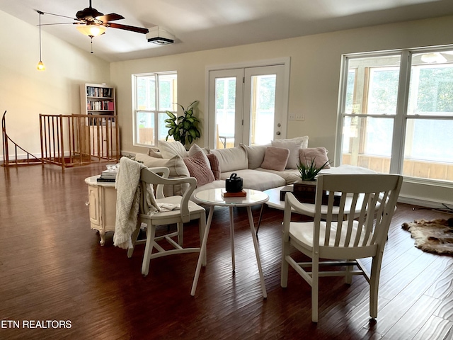 living area featuring vaulted ceiling, ceiling fan, and dark wood finished floors