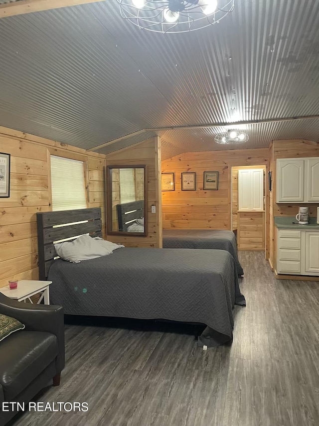 bedroom with lofted ceiling, wood finished floors, and wooden walls