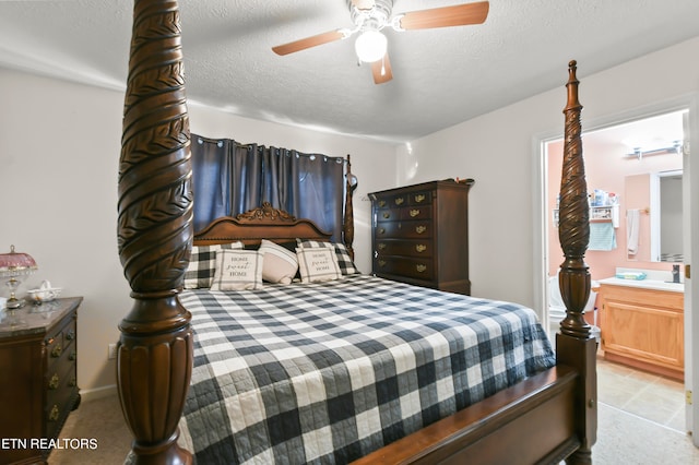 bedroom featuring a textured ceiling, light colored carpet, and ceiling fan