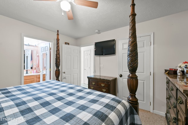 carpeted bedroom featuring ensuite bath, a textured ceiling, and ceiling fan