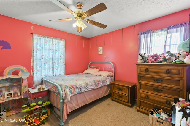 bedroom featuring ceiling fan, light colored carpet, and a textured ceiling