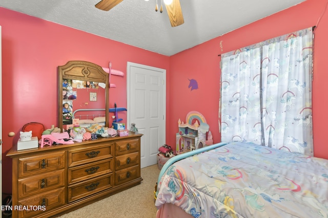 carpeted bedroom featuring a textured ceiling and ceiling fan