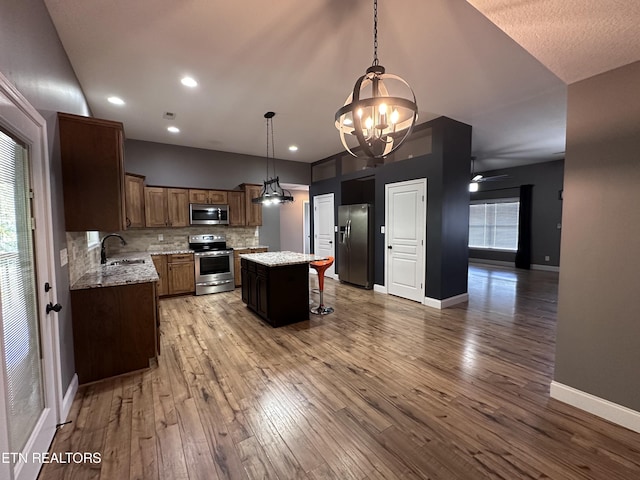 kitchen featuring a sink, stainless steel appliances, tasteful backsplash, and light wood finished floors