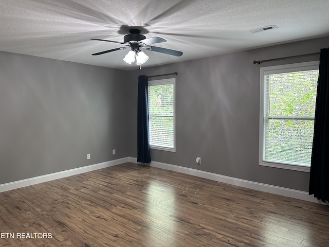 spare room featuring visible vents, baseboards, and wood finished floors