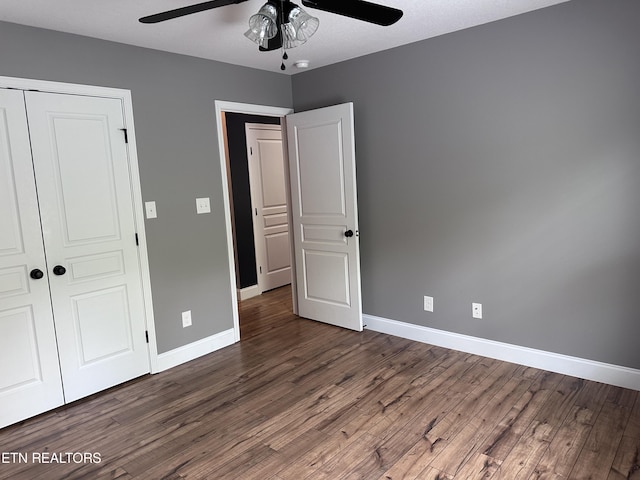 unfurnished bedroom with a closet, baseboards, and wood finished floors