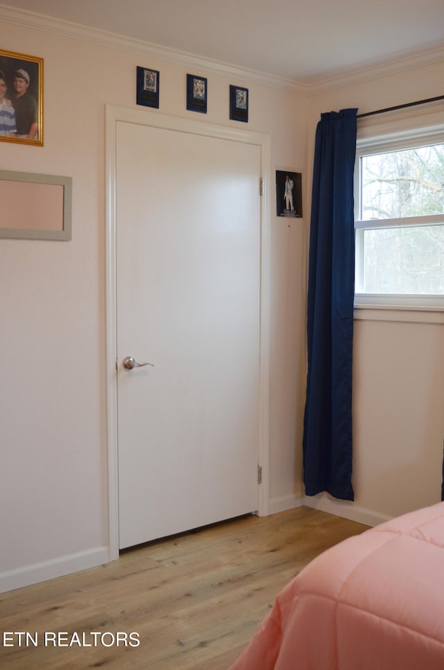 bedroom with light hardwood / wood-style floors and crown molding