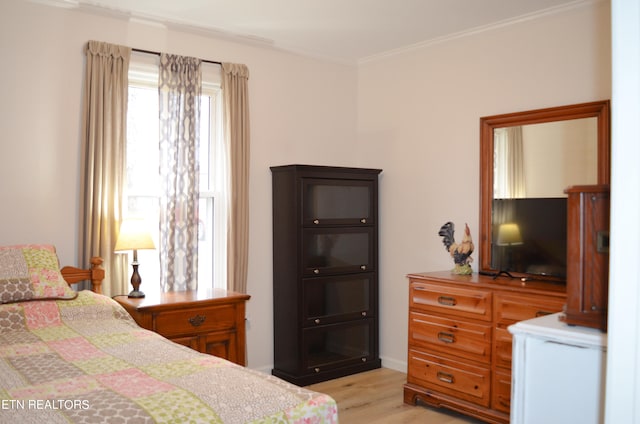 bedroom with crown molding and light hardwood / wood-style flooring