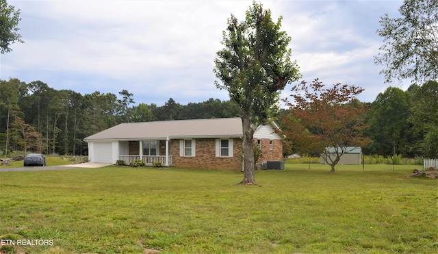 single story home with a garage, a front yard, and a porch