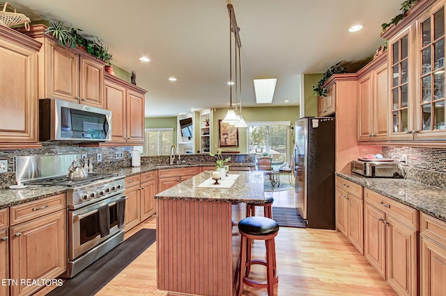 108 Waynoka Ln, Loudon, TN 37774 - kitchen featuring tasteful backsplash, stainless steel appliances, a center island, a breakfast bar, and light wood-style flooring
