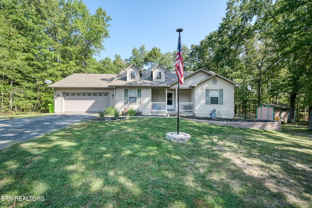 view of front of house featuring a front yard, a porch, a garage, and a storage shed