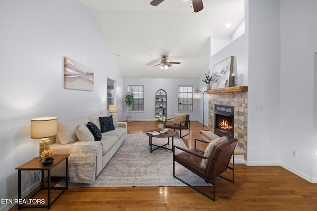 living room with hardwood / wood-style flooring, ceiling fan, and high vaulted ceiling