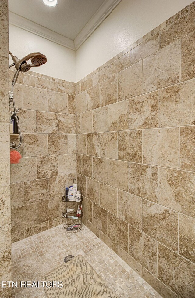 bathroom featuring a tile shower and ornamental molding