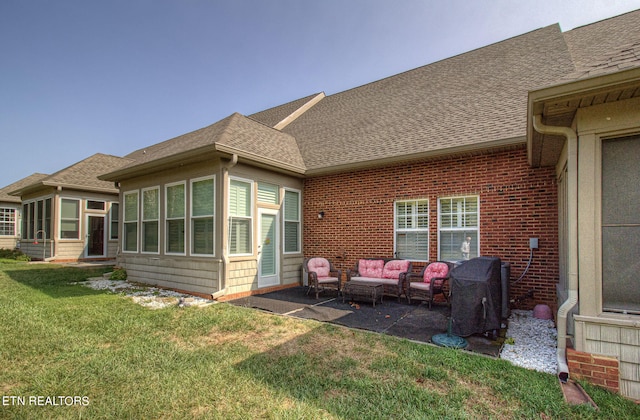 rear view of property featuring a lawn, an outdoor living space, and a patio