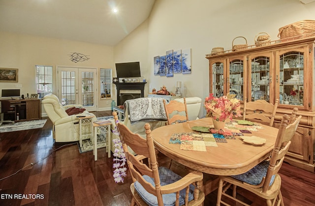 dining area featuring dark hardwood / wood-style flooring and high vaulted ceiling