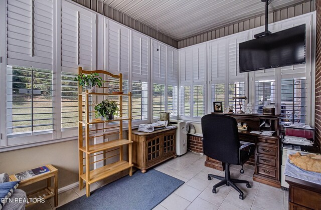 office featuring light tile patterned floors, a wealth of natural light, and wood walls