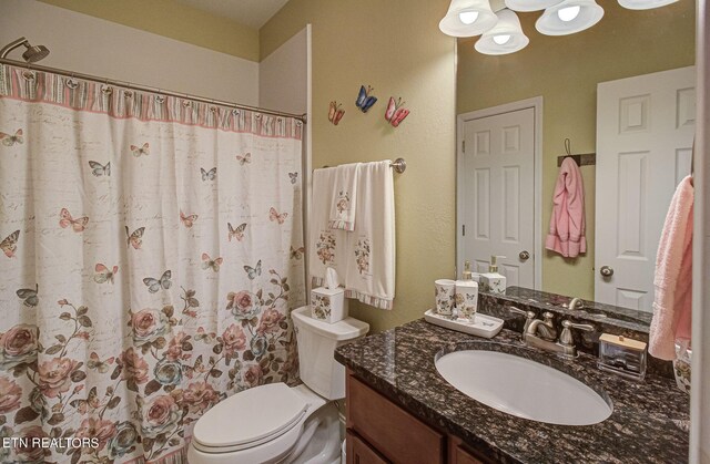 bathroom featuring a shower with shower curtain, toilet, and vanity