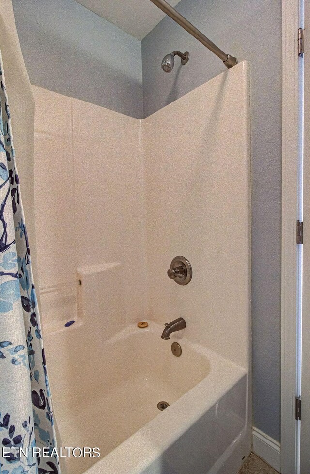 bathroom with shower / bath combination with curtain