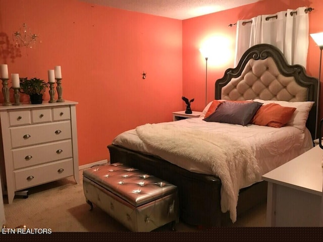 bedroom featuring a textured ceiling and light carpet