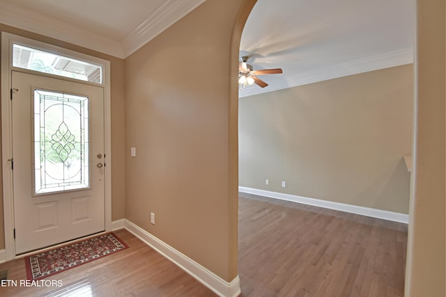 foyer entrance featuring light wood-type flooring, ornamental molding, and ceiling fan