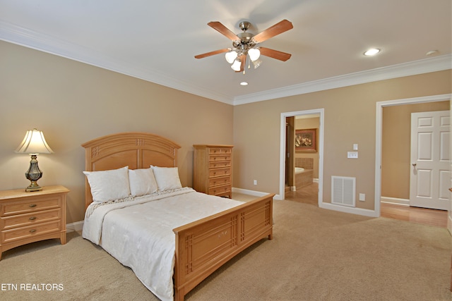 carpeted bedroom with ensuite bath, crown molding, and ceiling fan