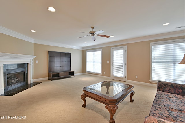 carpeted living room featuring ceiling fan, a fireplace, and crown molding