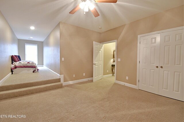 unfurnished bedroom featuring light colored carpet, ceiling fan, and a closet