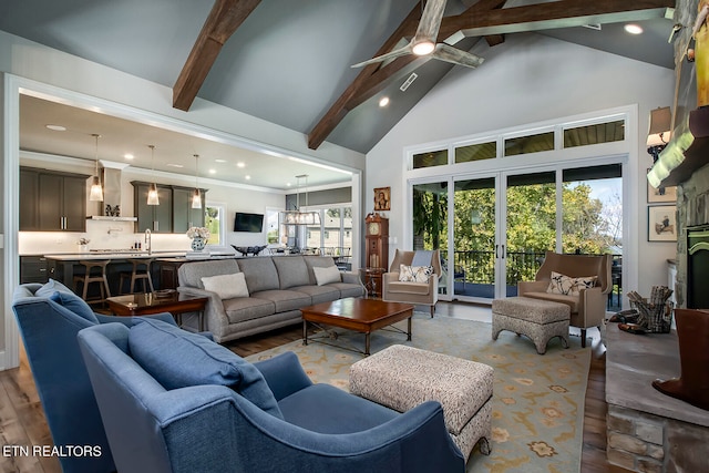 living room with ceiling fan, beam ceiling, and wood-type flooring