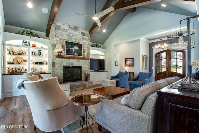 living room with hardwood / wood-style floors, high vaulted ceiling, beam ceiling, and a stone fireplace