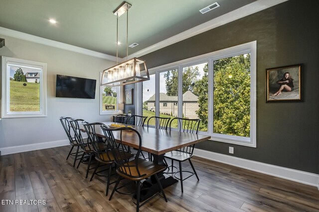 dining space with crown molding, dark hardwood / wood-style floors, and a notable chandelier