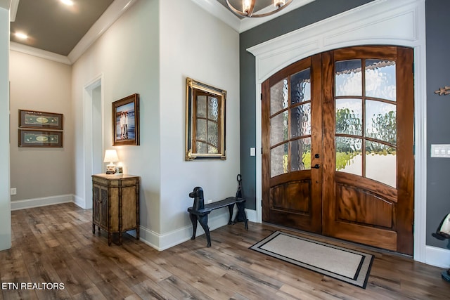 entryway with wood-type flooring, crown molding, and french doors