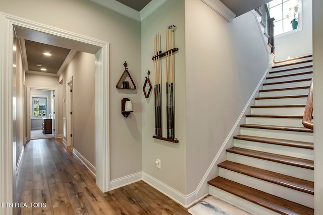 stairway with crown molding and hardwood / wood-style flooring