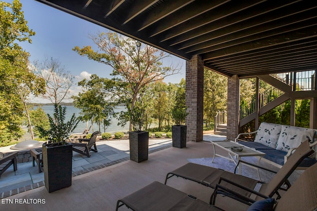 view of patio with an outdoor fire pit and a water view