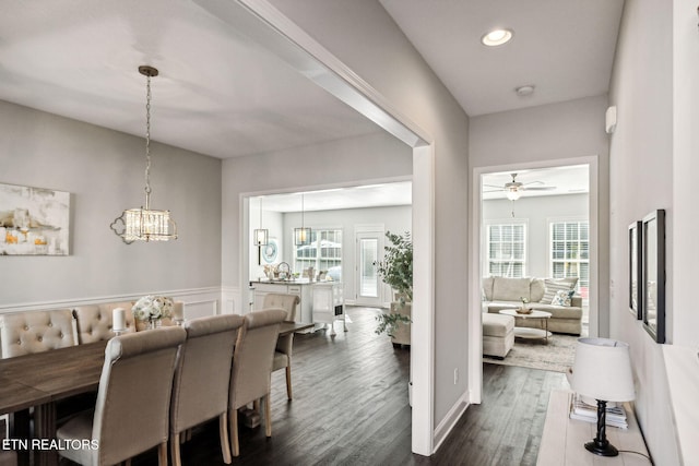 dining space featuring ceiling fan with notable chandelier, dark hardwood / wood-style flooring, and a healthy amount of sunlight