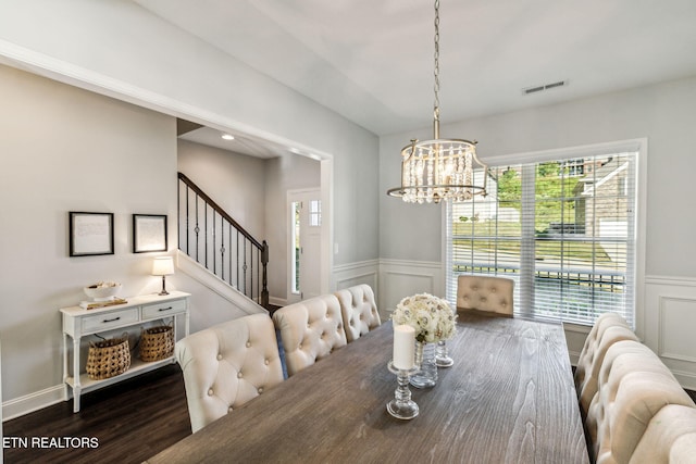 dining room with dark hardwood / wood-style floors and a chandelier