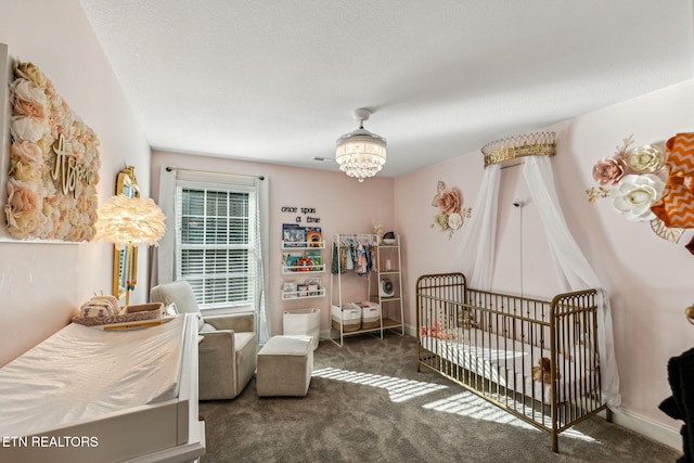 carpeted bedroom featuring a nursery area and an inviting chandelier