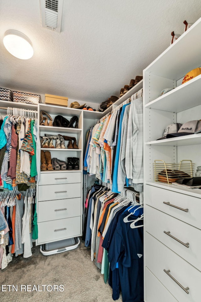 walk in closet featuring light carpet