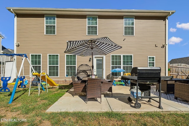 back of property with a playground and a patio