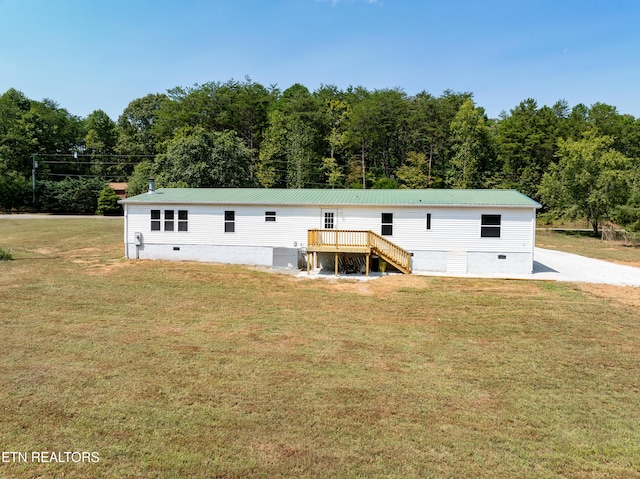 view of front of property with stairway, a front yard, metal roof, a deck, and crawl space