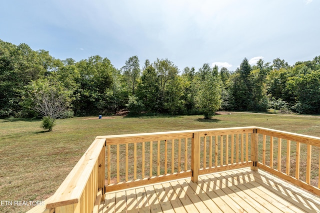 wooden terrace featuring a lawn