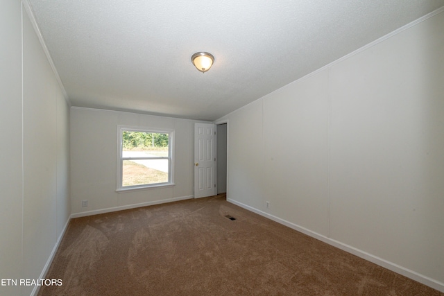 empty room with baseboards, visible vents, carpet floors, ornamental molding, and a textured ceiling