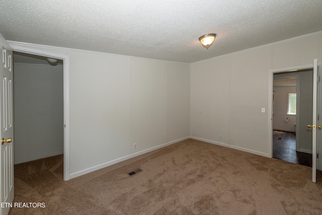 unfurnished bedroom with carpet flooring, visible vents, and a textured ceiling